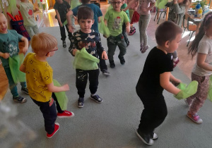 Dzieci bawią się z zielonymi chusteczkami